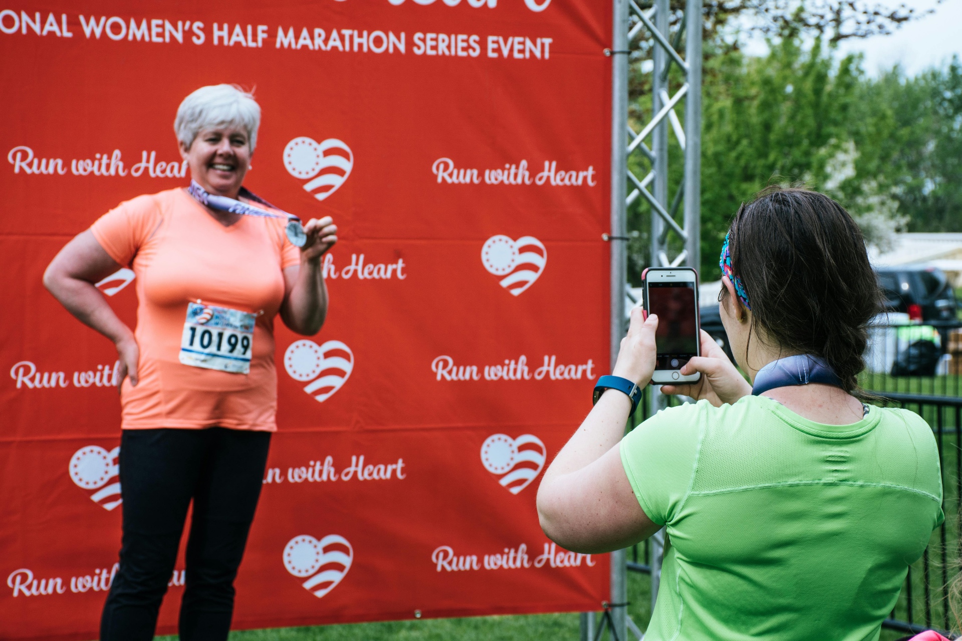 Participant posing with a medal after a community running event