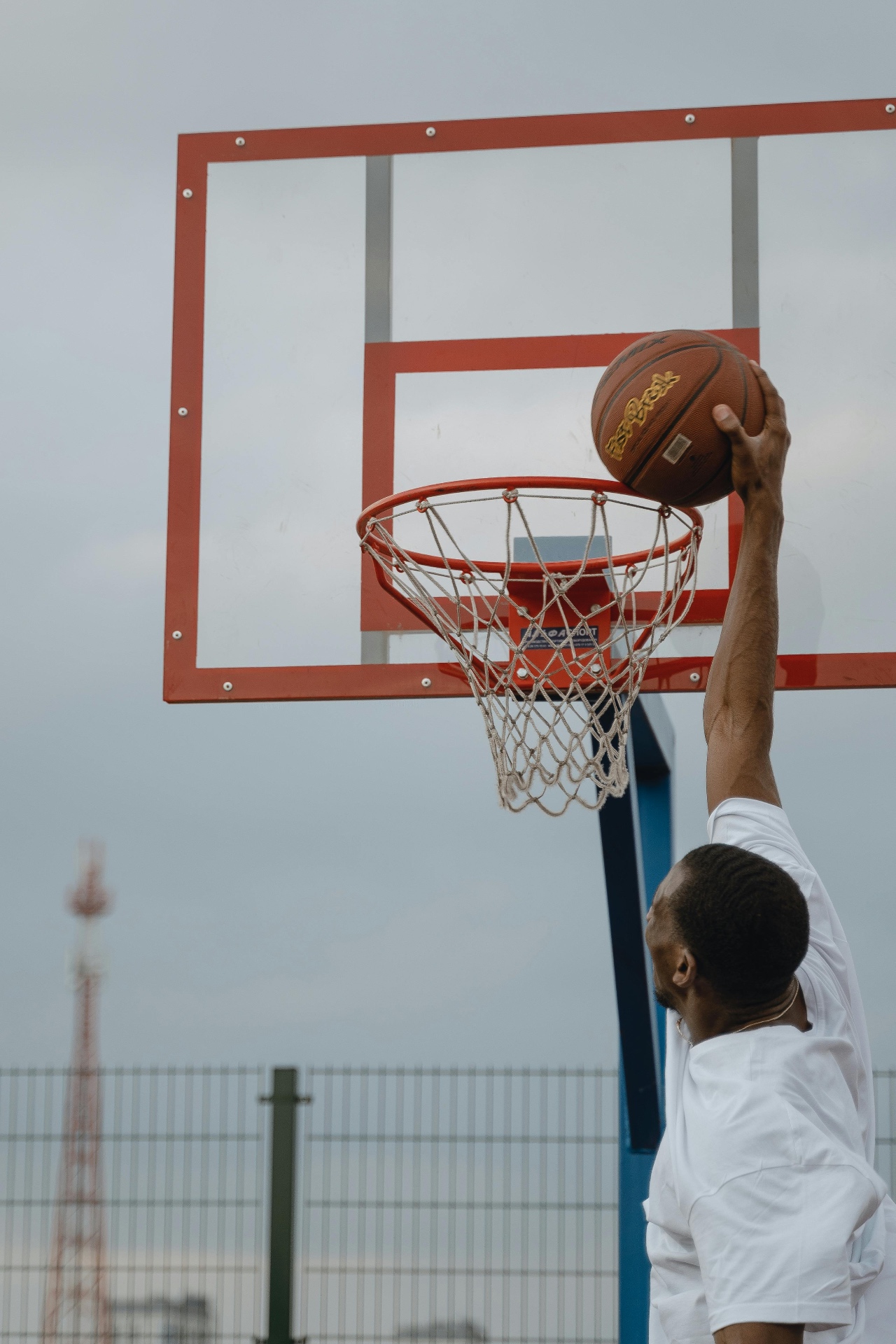Basketball player dunking on an outdoor court