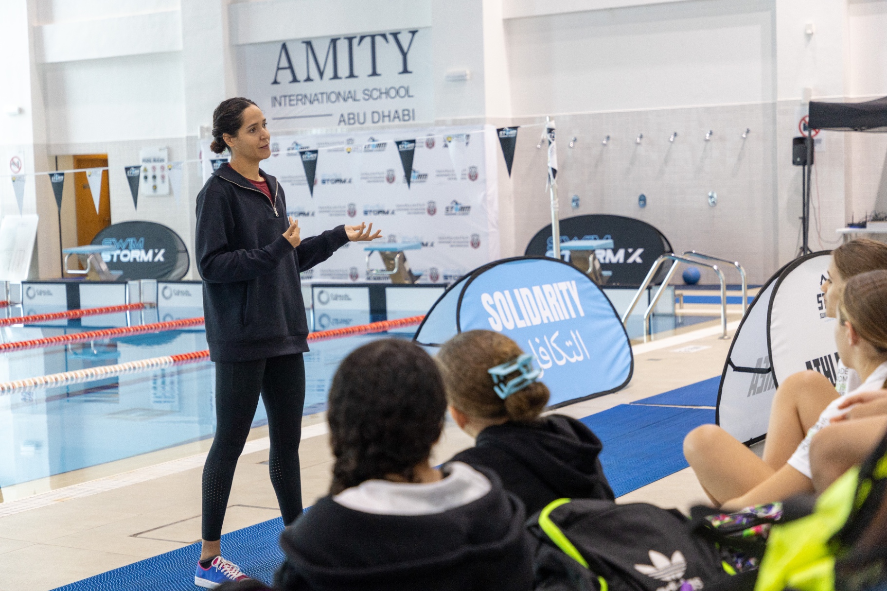Dr Sarra Lajnef-Taylor mentoring young swimmers poolside at Amity International School Abu Dhabi